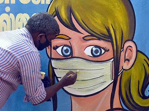 An artist paints 'No mask No Entry' graffiti at Chennai Central Railway station. Express/ Martin Louis