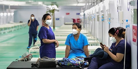Health workers wait for their duty schedule, at the 500 ICU beds service for COVID-19 patients at Ramlila Maidan opposite GTB hospital in New Delhi. (Photo | PTI)