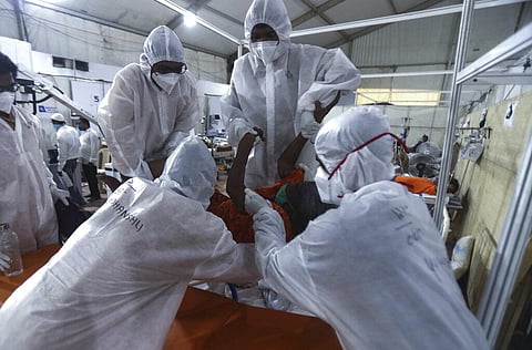 Health workers attend to a patient at the BKC jumbo field hospital, one of the largest COVID-19 facilities in Mumbai. (Photo | AP)