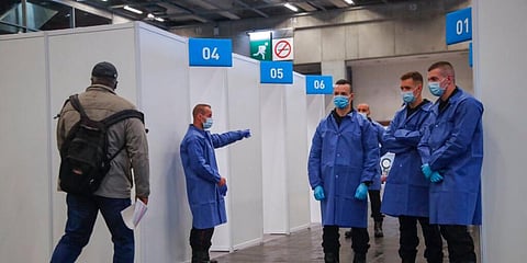 A man is guided into a vaccine box to get a Pfizer COVID-19 shot at a new vaccination near Paris airport. (Photo | AP)