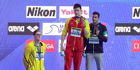 China's Sun Yang (C) holds up his gold medal as silver medalist Australia's Mack Horton (L) stands away from the podium after the men's 400m freestyle final at the WSC in Gwangju. (Photo | AP)