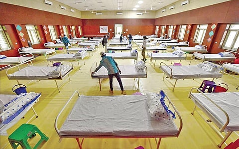 Workers prepare beds at a Covid care centre inside a school hall, in New Delhi. (Representational Photo | PTI)