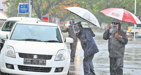 Disregarding the heavy rain, policemen stop travellers to check whether they were carrying the required documents. (Photo| A Sanesh, EPS)