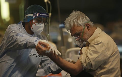 A Covid-19 patient on an oxygen support inside a Covid-19 care center set up at Shehnai Banquet in New Delhi on Monday. (Photo | Shekhar Yadav, EPS)