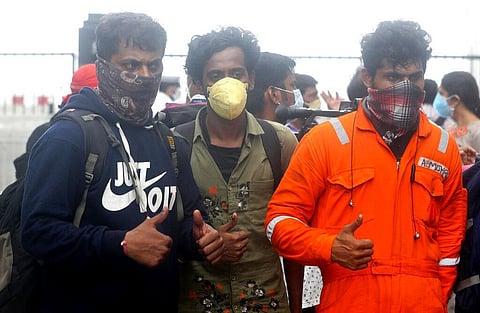 People rescued by the Indian navy from the Arabian sea flash the thumbs up sign after arriving in a helicopter at naval air station INS Shikra in Mumbai. (Photo | AP)