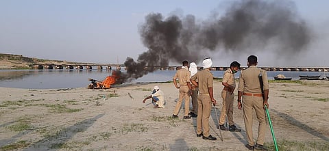 A man cremating the body under police supervision. (Photo | Special arrangement)
