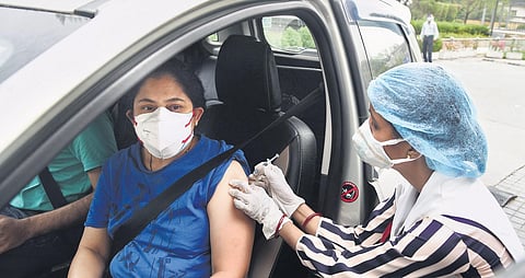 Health workers administer doses of Covid-19 vaccine to people at a drive-through vaccination camp at a mall in Noida on Monday | Parveen negi