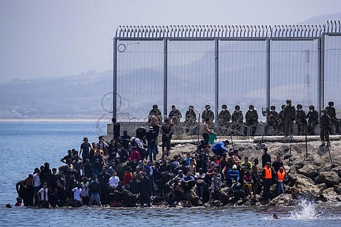 Migrants wait to cross into the Spanish enclave of Ceuta, near the border of Morocco and Spain. (Photo | AP)