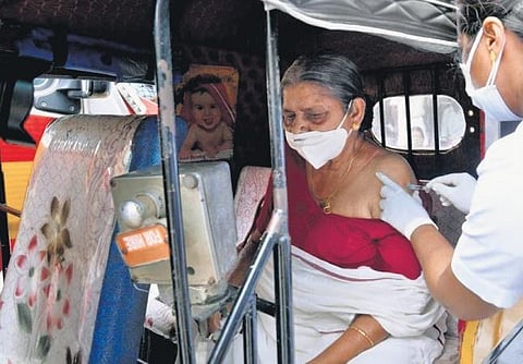 A health worker administers the vaccine to an elderly woman in an autorickshaw stationed outside a vaccination centre in Thiruvananthapuram | File Pic