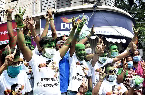 TMC supporters wearing Chief Minister Mamata Banerjee printed shirts showing a victory sign after winning the West Bengal Assembly election, in Kolkata on Sunday. (Photo | ANI)