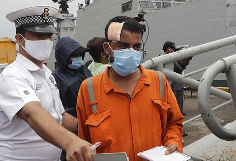 People rescued by the Indian navy from a barge that sank in the Arabian sea walk out from Indian naval ship INS Kochi in Mumbai. (Photo | AP)