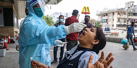 A health worker collects swab sample of a woman for COVID-19 test at Medical square in Nagpur, Wednsday. (Photo | PTI)