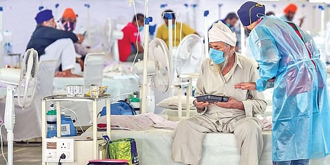 A patient at the Guru Tegh Bahadur Covid care centre at Gurdwara Rakab Ganj Sahib in New Delhi on Thursday. (Photo | PTI)