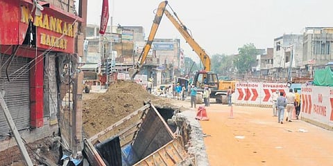 A truck fell in a caved-in part of a road near a metro construction site at Khera More in Najafgarh area of New Delhi. (Photo | Shekhar Yadav, EPS)