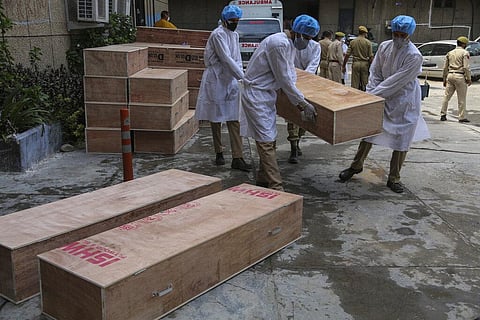 Jammu and Kashmir State Disaster Response Force soldiers carry empty coffins for transporting bodies of people who died of COVID-19 outside government medical hospital in Jammu. (Photo | AP)