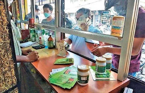 People purchase Ayurvedic medicines, which have been selling like hot cakes in Karimnagar, at a medical shop in the town on Saturday.