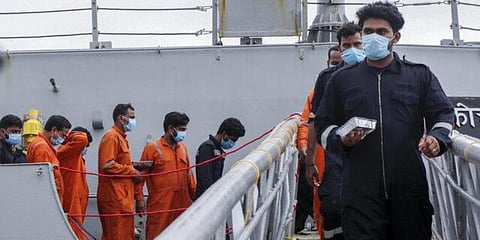 People rescued by the Indian Navy from a barge that sank in the Arabian sea walk out from Indian naval ship INS Kochi in Mumbai. (Photo | AP)