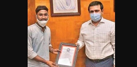 Santosh receiving ‘Champion of Charity’ award from the Vizag collector | express