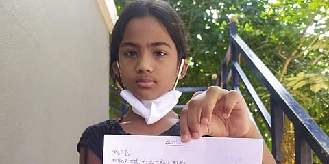 Hritiksha shows her letter to district administration in Madikeri. (Photo | Express)