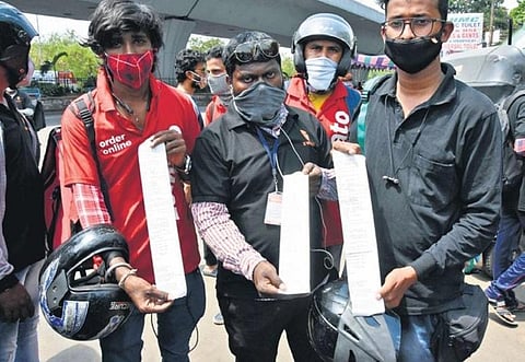 Delivery agents show challans issued by the police for delivering food items during lockdown hours, in Hyderabad on Saturday. (Photo | RVK Rao, EPS)