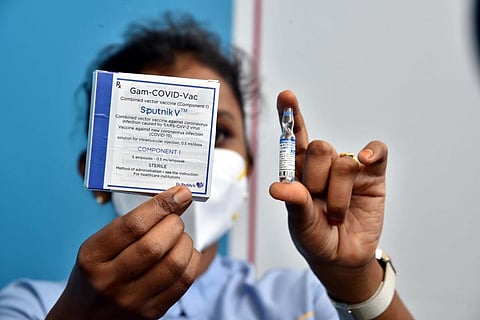 A health worker shows a vial of Sputnik V COVID-19 vaccine during its administration to the employees of Dr. Reddys Laboratories as a pilot drive, in Hyderabad. (Photo | Special Arrangement)
