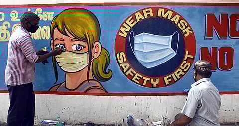 An artist paints 'No mask No Entry' graffiti at Chennai Central Railway station. (File Photo | Martin Louis, EPS)