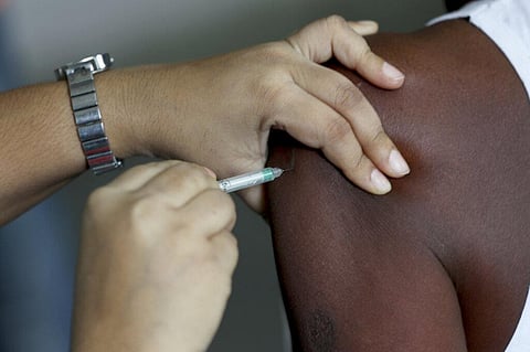 A health worker inoculates a man against the coronavirus at a vaccination camp held in the premises of a school in Bengaluru. (Photo | AP)
