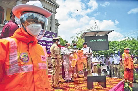 Home Minister Basavaraj Bommai handing out raincoats, masks, and face shields to personnel of the Bengaluru City Traffic Police at Town Hall in Bengaluru on Wednesday | Shriram BN