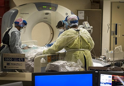Medical workers prepare a COVID positive patient for a CT Scan (Photo | AP)