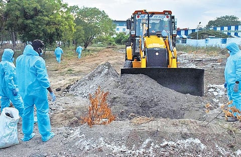 An earthmover being used to dig and level a burial pit for a Covid-19 victim at a mosque near Flower Market in Coimbatore city | U Rakesh Kumar