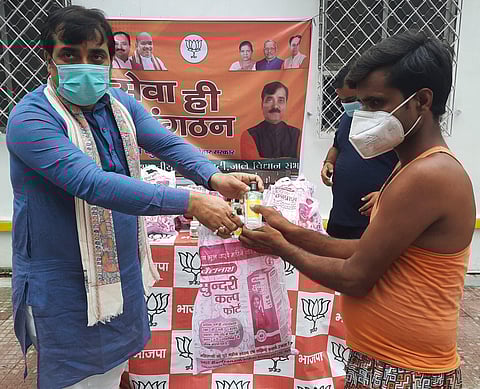 Bihar Minister of Labour Resource Jivesh Kumar giving away immunity kits to a construction worker at patna.