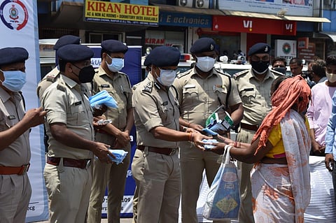 Raipur Police distributing a face mask to a woman (Photo | Express)