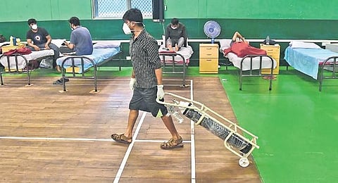 A ward boy wheels an oxygen cylinder for a patient inside a temporary Covid Care Centre at the Adugodi Sports Complex in Bengaluru on Tuesday | ASHISHKRISHNA HP