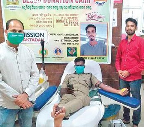 A police personnel donating blood at a camp organised by Niranjan and Haraprasad in Bhubaneswar. (Photo | EPS)