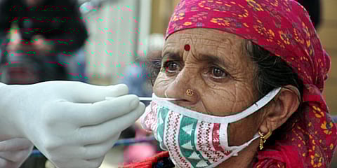 A medic collects a swab sample of a woman for the COVID-19 test amid the rise in cases, in Kullu. (Photo| ANI)