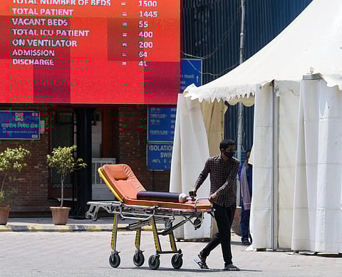 A man pulls a stretcher with an oxygen cylinder, at LNJP hospital in New Delhi on Thursday. (Photo | ANI)