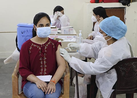 A medical worker inoculates a young woman with a dose of COVID-19 vaccine, at a vaccination centre in Jammu. (Photo | PTI)