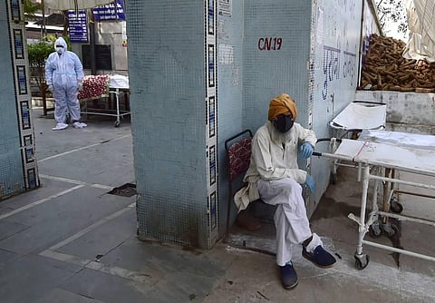 A family member before cremation of a COVID-19 victim at the Old Seemapuri Cremation Ground. (Photo | PTI)