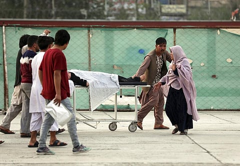 An injured school student is transported to a hospital after a bomb explosion near a school west of Kabul, Afghanistan. (Photo | AP)