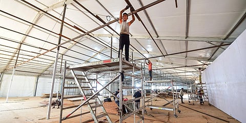 Workers prepare a temporary COVID Care Centre at Ramlila Ground. (Photo| PTI)