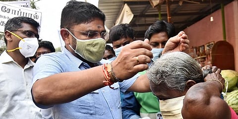 Chennai corporation commissioner G Prakash offers face mask to an elderly woman during an awareness programme on COVID. (Photo | EPS)