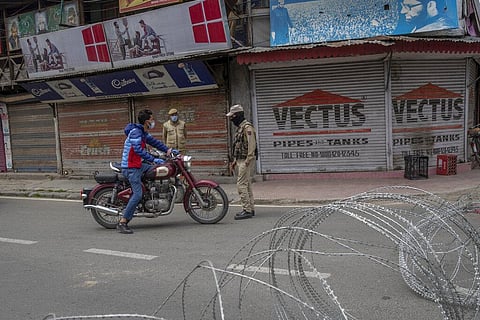 An Indian police man interrogates a Kashmiri motorcyclist before turning him back during a lockdown to curb the spread of coronavirus in Srinagar. (Photo | AP)