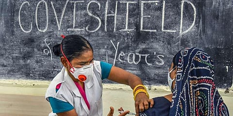 A medic inoculates a dose of a Covid-19 vaccine to a woman, at a vaccination centre, in Ajmer. (Photo | PTI)