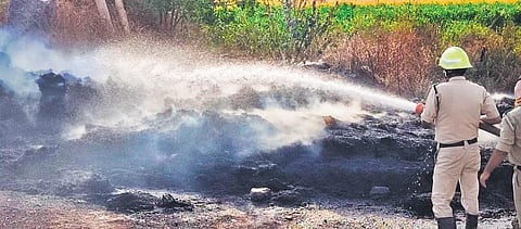 Fire safety officials douse flames that engulfed two fields after farmers burnt stubble for cultivation of next crop.