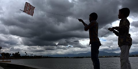 Rain clouds form near Ukkadam lake while boys fly kite in Coimbatore. (Photo | U Rakesh Kumar, EPS)