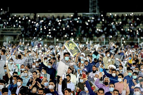 A supporter of the presidential candidate Ebrahim Raisi, currently judiciary chief, hold his posters during a campaign rally at the Takhti Stadium in Ahvaz, Iran. (Photo | AP)
