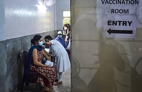 A health worker administers a dose of the COVID-19 vaccine to a woman, at a vaccination centre in Kolkata. (File Photo | PTI)