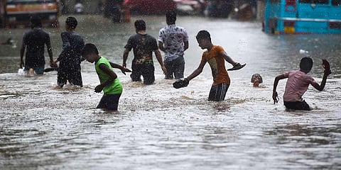 Children play in a waterlogged street, at Kurla in Mumbai. (Photo | PTI)