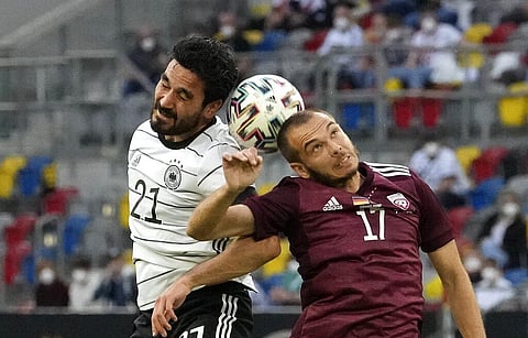Germany's Ilkay Gundogan, left, and Latvia's Arturs Zjuzins challenge for the all during the international friendly soccer match between Germany and Latvia in Duesseldorf. (Photo | AP)