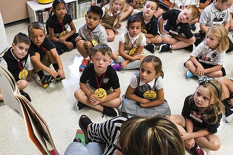 Students from two kindergarten classes at the Lewiston elementary campus of Saint Dominic Academy, listen to a teacher read a book (Photo | AP)